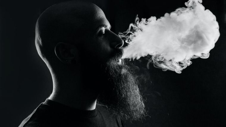 A man exhaling smoke from a vape