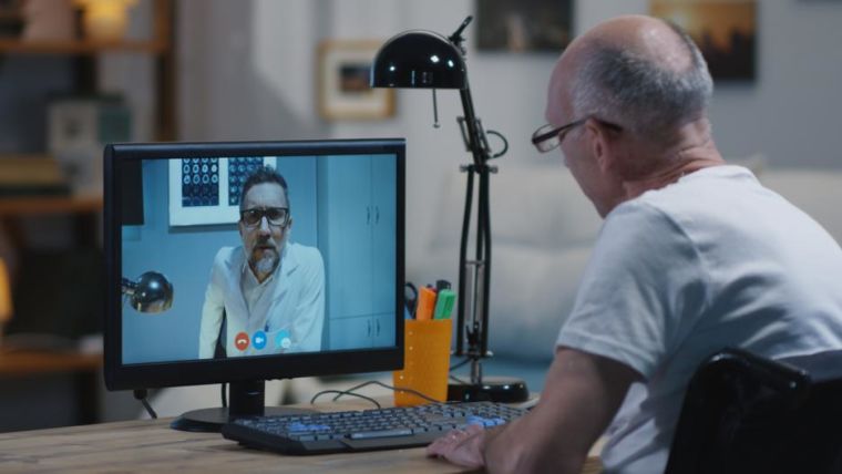 Medium shot of a disabled man talking to his doctor during a video chat