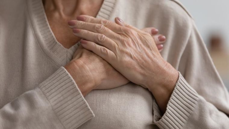 Close-up cropped image of older woman crossing her hands over her chest