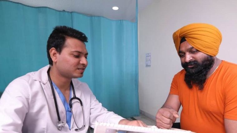 Image of consultation in clinical setting between Indian patient and doctor