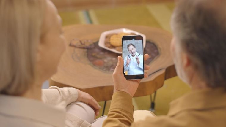Image of two older people talking to a doctor on their mobile phone